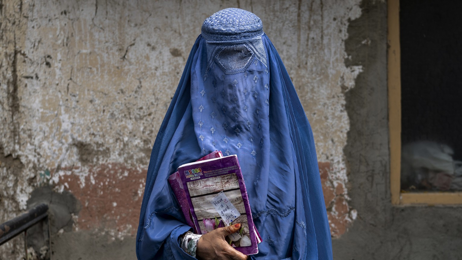 FILE- Arefeh 40-year-old, an Afghan woman leaves an underground school, in Kabul, Afghanistan, Saturday, July 30, 2022. Afghan girls will be allowed to take their high school graduation exams this wee ...
