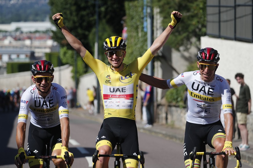 epa09351994 Slovenian rider Tadej Pogacar (C) of the UAE-Team Emirates wearing the overall leader&#039;s yellow jersey is flanked by teammates during the 21st stage of the Tour de France 2021 over 108 ...