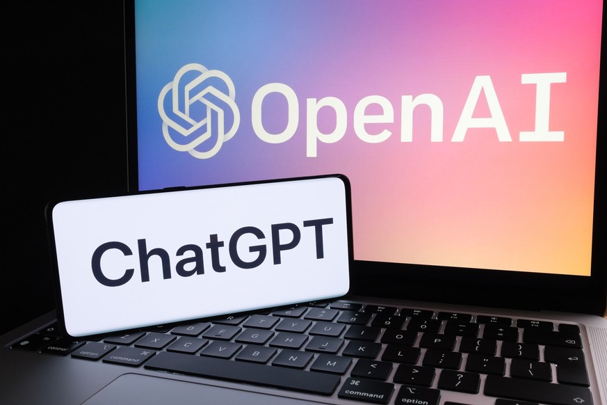 ChatGPT logo seen on smartphone and laptop display with blurred OpenAI company logotype. AI chatbot by OpenAI. Stafford, United Kingdom, December 20, 2022.