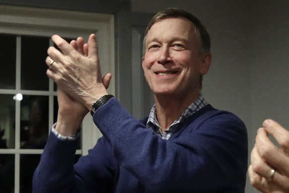 FILE - In this Feb. 13, 2019, file photo, former Colorado Gov. John Hickenlooper, left, applauds at a campaign house party, in Manchester, N.H. Hickenlooper is running for president, becoming the seco ...