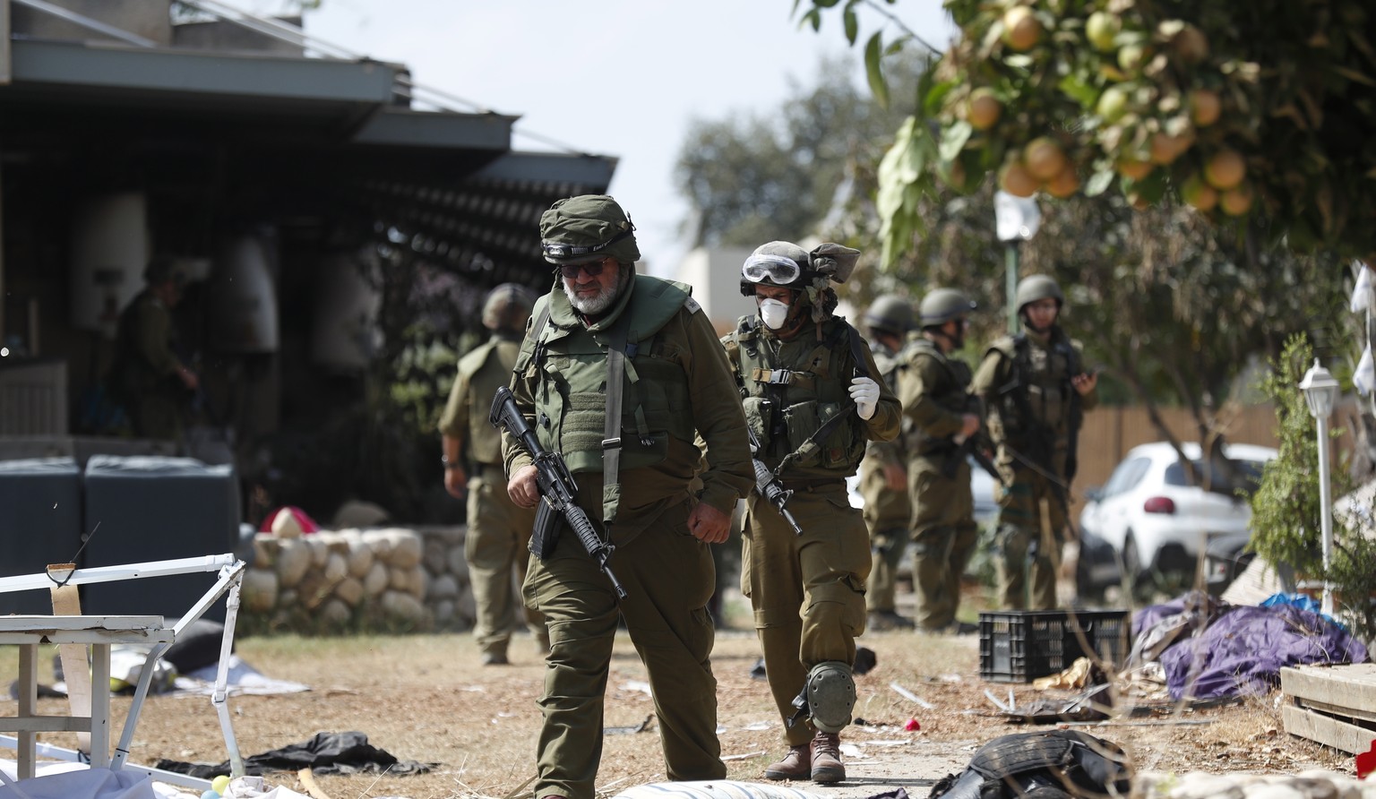 epa11638041 (FILE) - Israeli soldiers walk next to the body of a Hamas militant in Kfar Aza kibbutz, near the border with Gaza, 10 October 2023 (reissued 02 October 2024). Upcoming 07 October 2024, ma ...