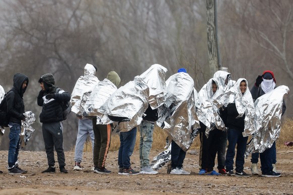 epa11076905 Migrants line up as they get ready to be picked up by Border Patrol agents in Eagle Pass, Texas, USA, 14 January 2024. The Texas Military Department confirmed that the Texas National Guard ...