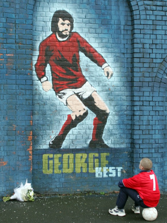 Ein junger Fussballfan bestaunt Best auf einem Wandgemälde in Belfast.