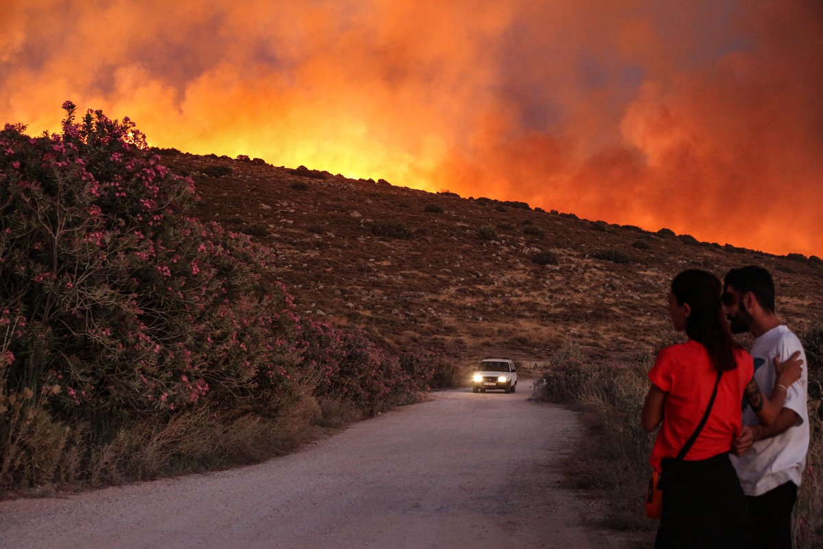 epaselect epa12213805 People look at a wildfire in the Cesme district of Izmir, Turkey, 03 July 2025. Wildfires in the Izmir region have killed two people and forced evacuations, according to Governor ...