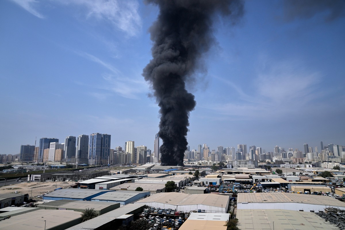 A black plume of smoke rises from a warehouse at the industrial area of Sharjah City in the United Arab Emirates following reports of Iranian strikes in Dubai, United Arab Emirates, Sunday, March 1, 2 ...