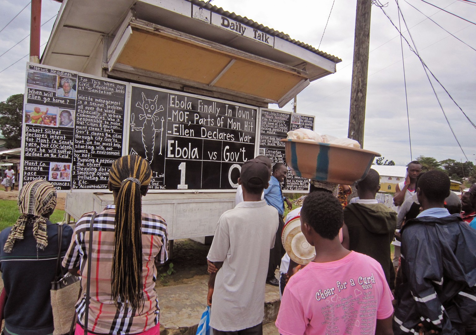Sozialarbeiter Alfred Sirleaf (mit blauem Hemd, vor der Tafel) zeigt nigerianischen Dorfbewohnern, wie sie sich vor dem tödlichen Ebola-Virus besser schützen können.
