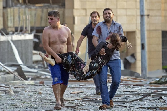 A wounded woman is evacuated after a massive explosion in Beirut, Lebanon, Tuesday, Aug. 4, 2020. (AP Photo/Hassan Ammar)