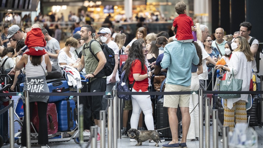 Menschen warten am Flughafen auf ihren Abflug in die Ferien, aufgenommen am Samstag, 16. Juli 2022 auf dem Flughafen in Zuerich. (KEYSTONE/Ennio Leanza)