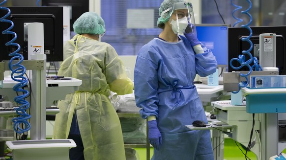 Aerzte und Pflegende kuemmern sich um Covid-Patienten in einer Intensivstation im Universitaetsspital Basel, am Montag, 28. Dezember 2020, in Basel. (KEYSTONE/Peter Klaunzer)