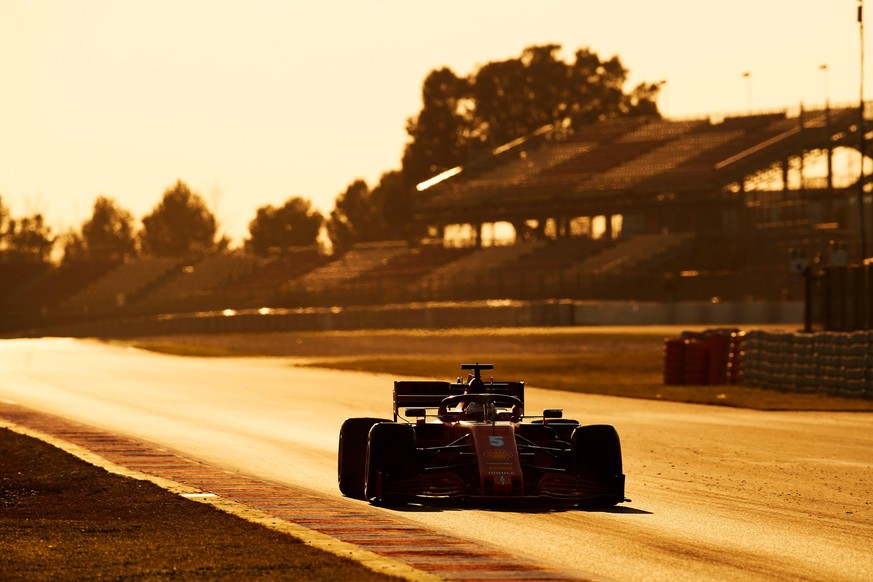 epa08446642 The sun casts a golden hue on the race track as German Formula One driver Sebastian Vettel rides his Ferrari a training session at the Barcelona-Cataluna Circuit, in Montmelo, outside Barc ...