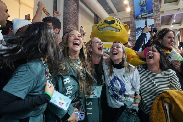 Supporters of Brazil's Lucas Pinheiro Braathen react at the Brazil House as he wins the men's giant slalom at the 2026 Winter Olympics, in Milan, Italy, Saturday, Feb. 14, 2026. (AP Photo/An ...