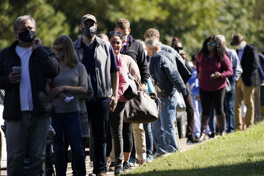 Voters brave a bright sun as they wait to cast their ballots at Precinct 45 in Jackson, Miss., Tuesday, Nov. 3, 2020. Some voters complained of slow moving lines after waiting for a couple of hours be ...