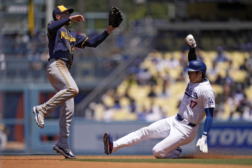 Los Angeles Dodgers&#039; Shohei Ohtani, right, slides into second in an attempt to steal as Milwaukee Brewers second baseman Brice Turang jumps over him during the third inning of a baseball game Sun ...