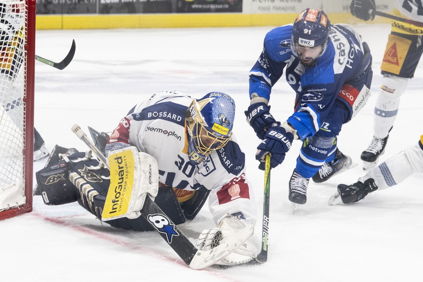 Zugs Torhueter Leonardo Genoni, links, kaempft um den Puck gegen Zuerichs Denis Hollenstein, rechts, im sechsten Eishockey Playoff-Finalspiel der National League zwischen den ZSC Lions und dem EV Zug  ...