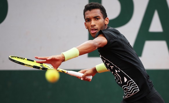 epa09979728 Felix Auger Aliassime of Canada eyes the ball in the men's third round match against Filip Krajinovic of Serbia during the French Open tennis tournament at Roland Garros in Paris, France, 27 May 2022.  EPA/MARTIN DIVISEK