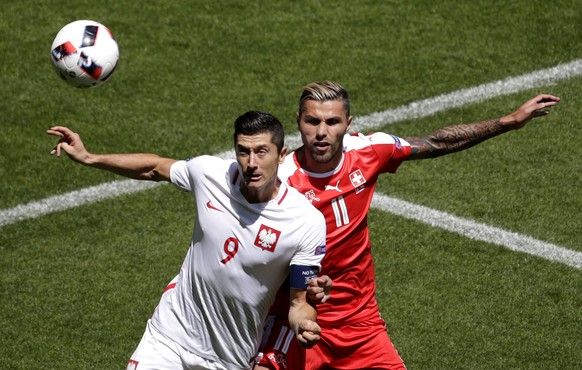 epa05389404 Robert Lewandowski of Poland (L) and Valon Behrami of Switzerland in action during the UEFA EURO 2016 round of 16 match between Switzerland and Poland at Stade Geoffroy Guichard in Saint-E ...