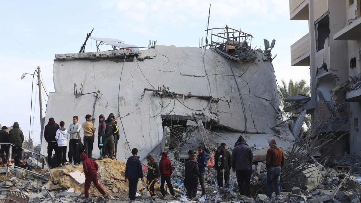 Palestinians look at the destruction after an Israeli strike on a residential building in Rafah, Gaza Strip, Friday, Feb. 16, 2024. (AP Photo/Hatem Ali)