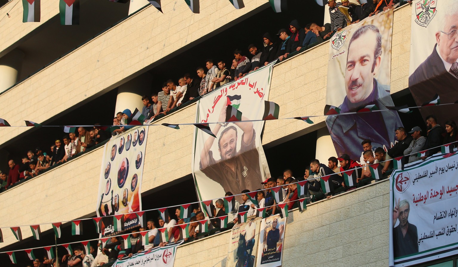 epa05911283 Palestinians hold pictures of their relatives held in Israeli jails during a supportive rally calling for the release of Palestinian prisoners in Israel, in the West Bank city of Nablus, 1 ...