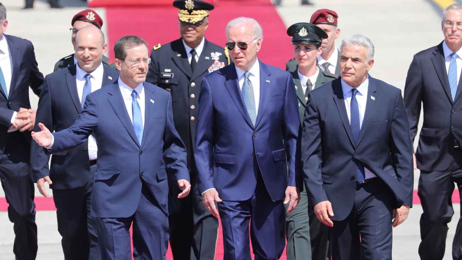 epa10068718 US President Joe Biden (C) is welcomed by Israeli Prime Minister Yair Lapid (R) and President Isaac Herzog (L) upon arrival at Ben Gurion Airport, in Lod, Israel, 13 July 2022. The US pres ...