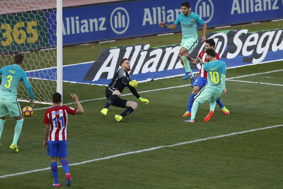 FC Barcelona Lionel Messi, right, scores a goal during a Spain's La Liga soccer match between Atletico de Madrid and FC Barcelona at the Vicente Calderon stadium in Madrid, Spain, Sunday, Feb. 26 ...