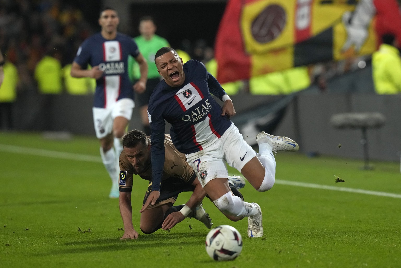 PSG&#039;s Kylian Mbappe is sent flying by a challenge from Lens&#039; Jonathan Gradit during the French League One soccer match between Lens and Paris Saint-Germain at the Bollaert stadium in Lens, F ...