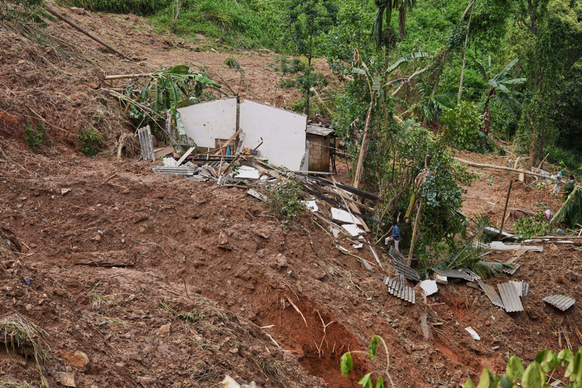 Überlebende eines Erdrutsches bergen Habseligkeiten.