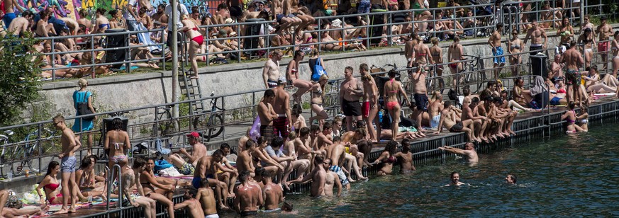 Menschen sonnen sich an der Limmat, aufgenommen am Pfingst-Montag, 9. Juni 2014 am Letten in Zuerich. Das hochsommerliche Wetter am Pfingstwochenende hat den Schweizer Freibaedern einen Besucheranstur ...