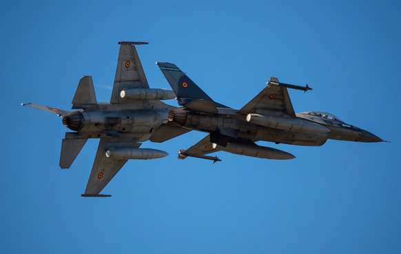FILE - Pilots of the Romanian Air Force fly F-16 fighter jets above the runway of the Aurel Vlaicu airport, on the first day of the Bucharest International Air Show, BIAS, in Bucharest, Romania, Satur ...