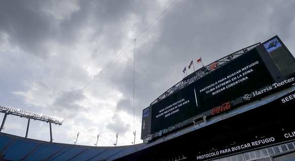 epa12203723 The Jumbotron directs all participants and fans to seek shelter as storm clouds gather over Bank of America Stadium during a weather delay late in the second half of the FIFA Club World Cu ...