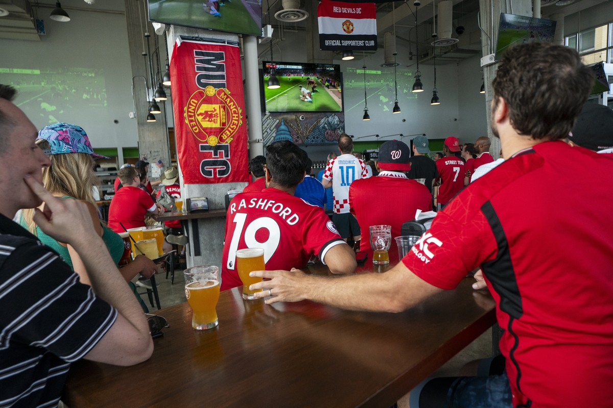 epa11552055 Fans of English Premier League soccer team Manchester Untied watch their team in the Premier League season opener against Fulham at Solace Outpost, the Red Devils DC fan club's chosen ...