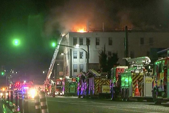 In this image made from video, firetrucks stage outside a hostel in central Wellington, New Zealand, early Tuesday, May 16, 2023. Several people were killed after a fire broke out overnight at the fou ...