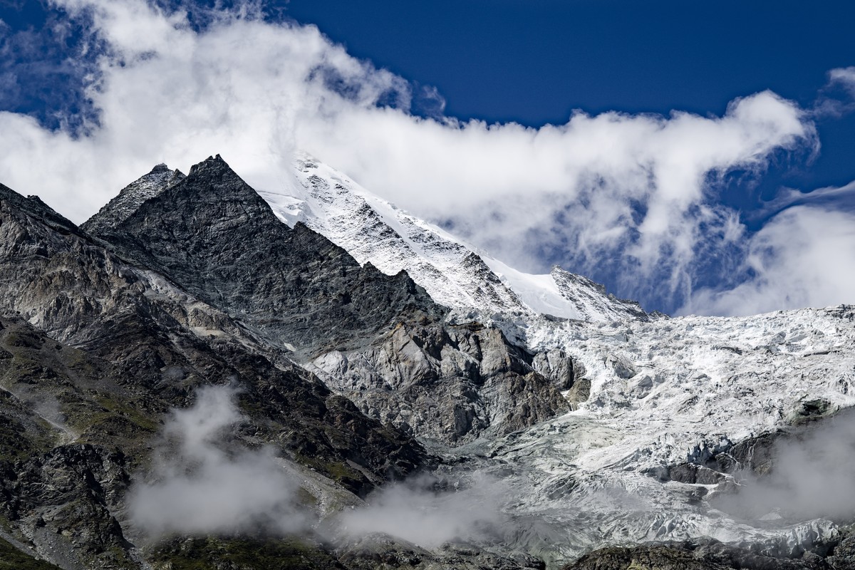Une vue du sommet de la montagne Weisshorn dans les nuages avec a gauche, le glacier suspendu du Weisshorn Est (Haengegletscher Weisshorn Ost) au-dessu du Bisgletscher le mardi 25 aout 2026 depuis Ran ...