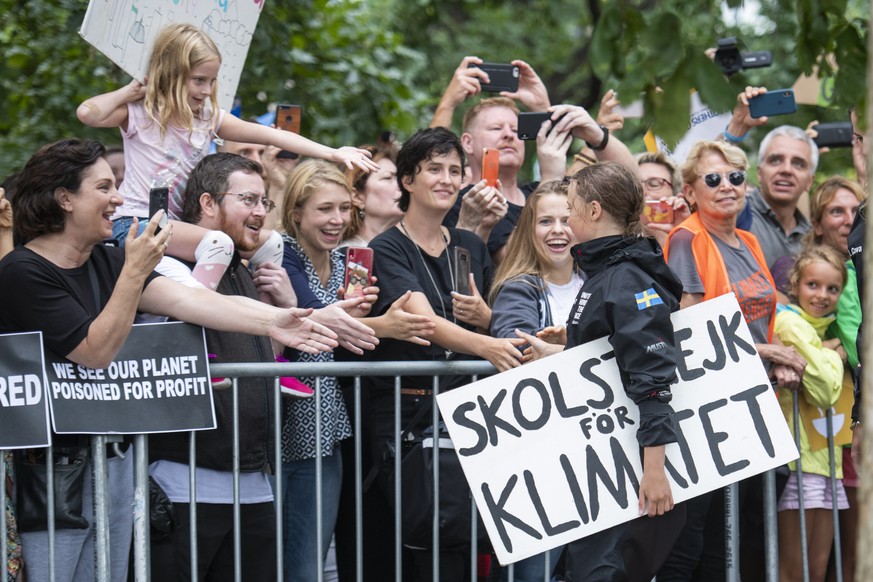 epa07800297 16-year-old climate change activist Greta Thunberg greets fans as she walks to a press conference from The Malizia II boat after it arrives in New York, USA 28 August 2019. Thunberg, who h ...