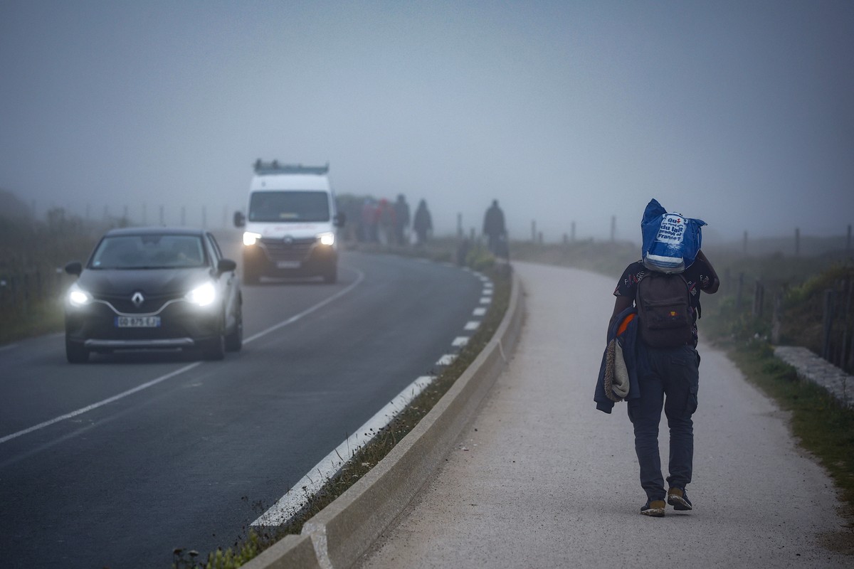 epa12244846 Migrants walk along the road early morning after attempting to cross the English Channel outside Wimereux, north of France, 18 July 2025. On July 10, 2025, during President Macron's s ...