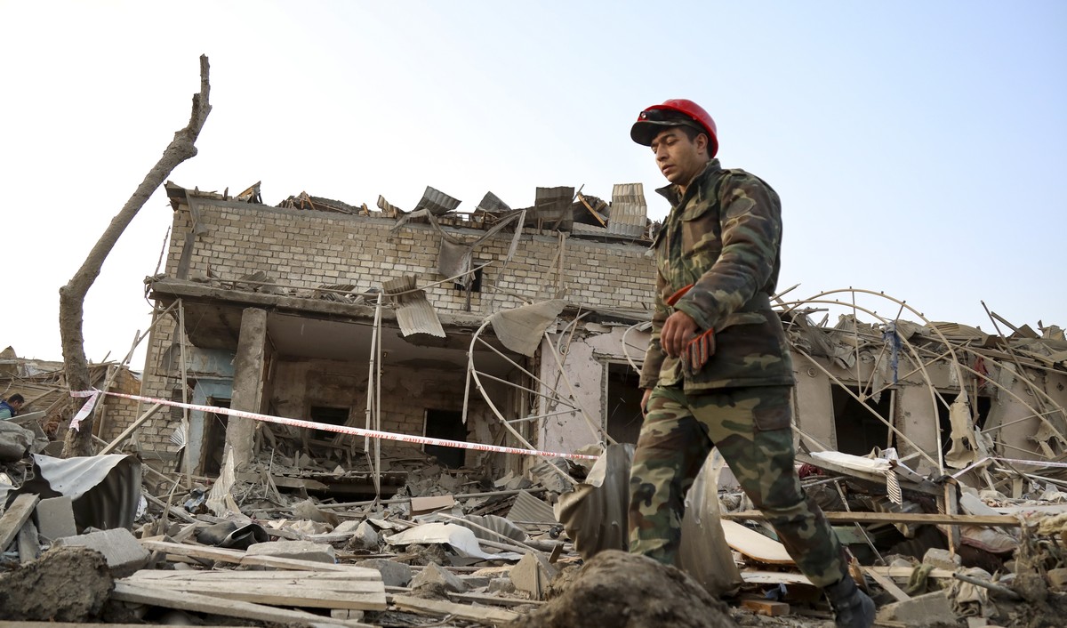 A soldier walks past a destroyed house in a residential area that was hit by rocket fire overnight by Armenian forces, early Saturday, Oct. 17, 2020, in Ganja, Azerbaijan's second largest city, n ...