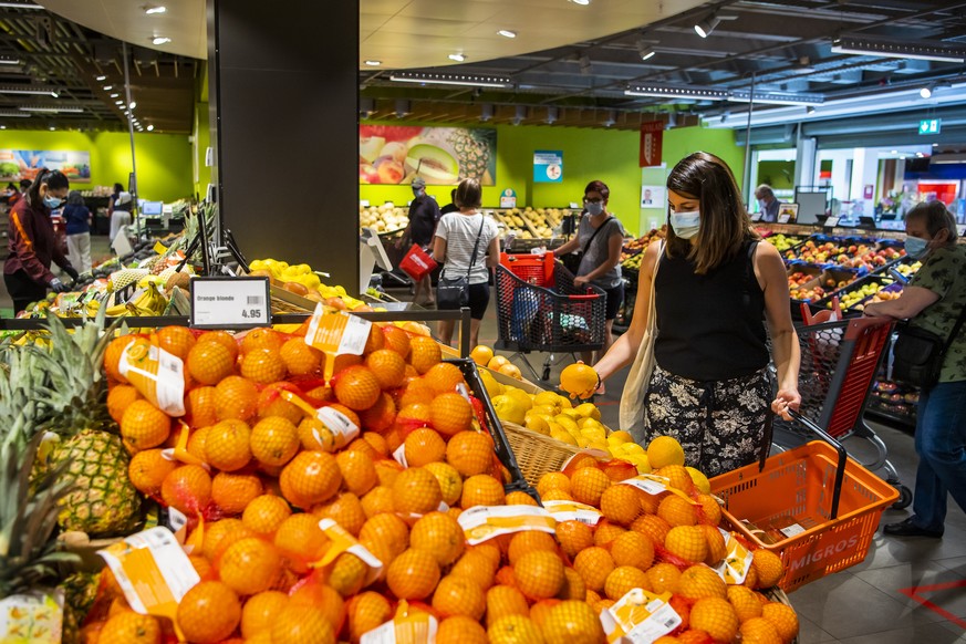 Une personne fait des courses avec un masque sur le visage dans un magasin Migros le mercredi 8 juillet 2020 a Crissier. Les masques sont obligatoires dans les magasins des 10 personnes dans le canton ...