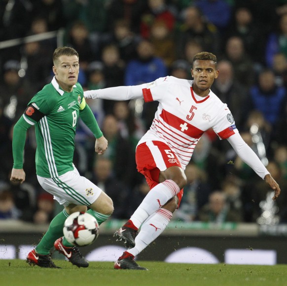 Northern Ireland&#039;s Steven Davis, left, challenges Switzerland&#039;s Manuel Akanji during the World Cup qualifying play-off first leg soccer match between Northern Ireland and Switzerland at Wind ...