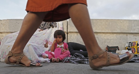 epa06850019 People enter the United States walk past two year old Jennifer and her mother Evelyn sleeping along with other immigrants from Guatemala and Cuba seeking asylum waiting in the middle of th ...