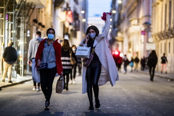 epa08818662 People stroll in via del Corso during the Coronavirus Covid-19 pandemic emergency in Rome, Italy, 13 November 2020. Italy authorities adopted new form of restrictions to curb the spread, i ...