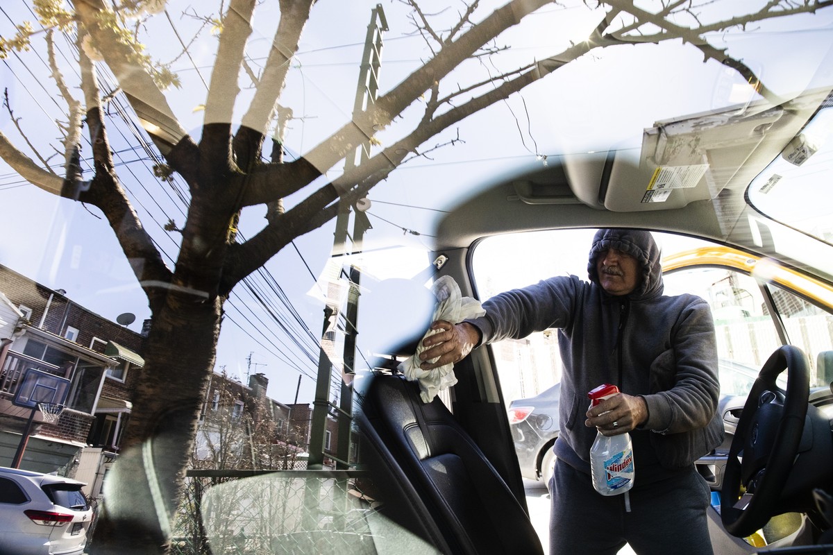 FILE - In this April 6, 2020, file photo, taxi driver Nicolae Hent cleans and disinfects his cab before starting work in New York. A taxi driver's job was already tougher in recent years with the ...