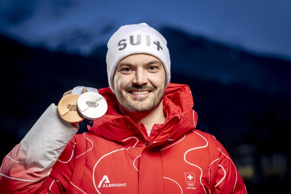 Bronze medalist Switzerland's Loic Meillard poses with his medals after the men's alpine skiing giant slalom race at the 2026 Olympic Winter Games at the Stelvio Ski centre in Bormio, Italy, ...