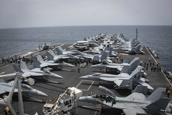 epa07586339 A handout photo made available by the US Navy shows sailors partaking in a foriegn obect and debris (FOD) walk-down on the flight deck of the Nimitz-class aircraft carrier USS Abraham Linc ...