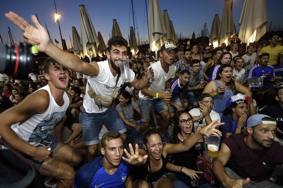 French soccer fans react as they watch a live broadcast of the semifinal match between France and Belgium at the 2018 soccer World Cup, in Marseille, southern France, Tuesday July 10, 2018. (AP Photo/ ...