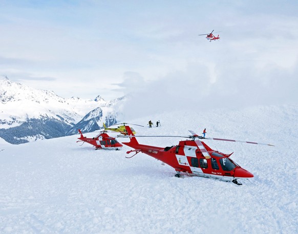 epa04597778 A handout image made available by Swiss Air-Rescue Rega (REGA) of rescue helicopters and rescue workers on duty after an avalanche accident at the Piz Vilan Mountain, eastern Switzerland,  ...