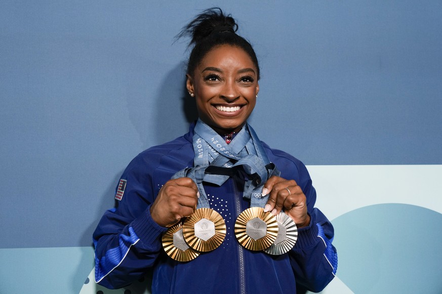 FILE - Simone Biles, of the United States, holds up her medals after the women's artistic gymnastics individual apparatus finals Bercy Arena at the 2024 Summer Olympics, Monday, Aug. 5, 2024, in ...