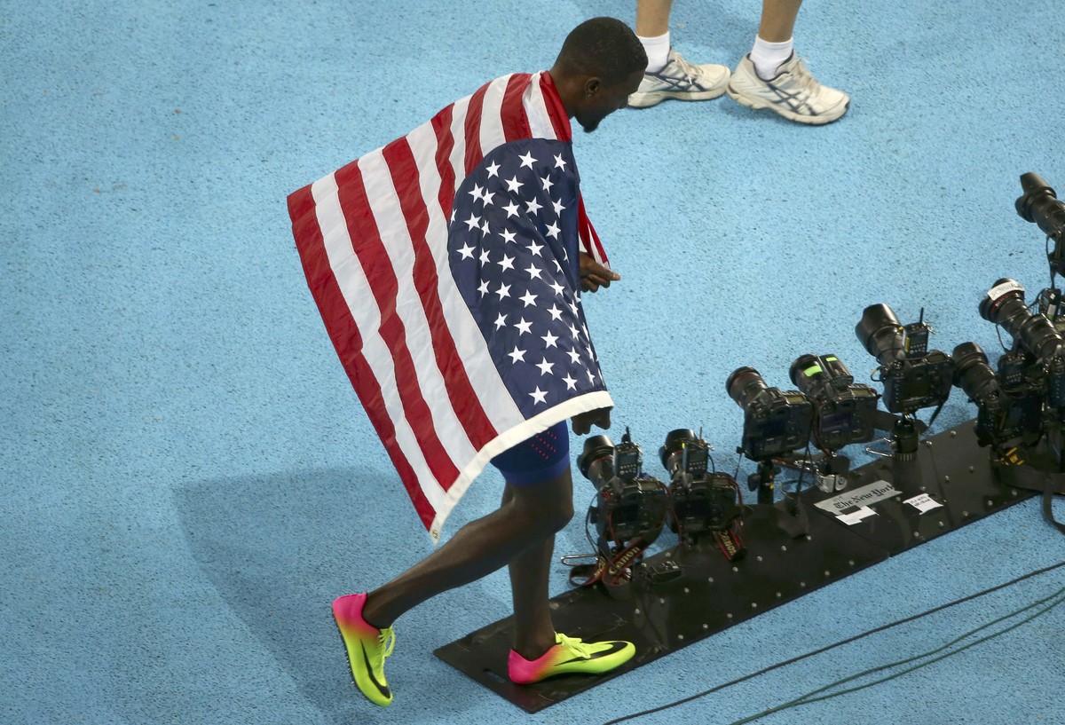 2016 Rio Olympics - Athletics - Final - Men's 100m Final - Olympic Stadium - Rio de Janeiro, Brazil - 14/08/2016. Justin Gatlin (USA) of United States walks with a flag after he won the silver me ...