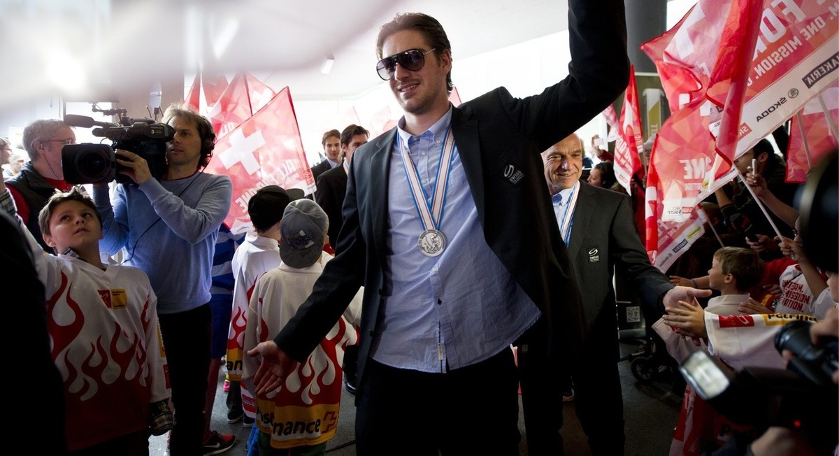 Spieler Reto Berra laeuft durch die Menschenmassen, anlaesslich der Ankunft der Schweizer Eishockey Nationalmannschaft am Montag, 20. Mai 2013 auf dem Flughafen in Zuerich Kloten. (KEYSTONE/Ennio Lean ...