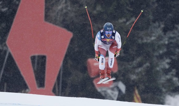 Switzerland's Niels Hintermann speeds down the course during an alpine ski, men's World Cup downhill training, in Kitzbuehel, Austria, Thursday, Jan. 20, 2022. (AP Photo/Giovanni Auletta)