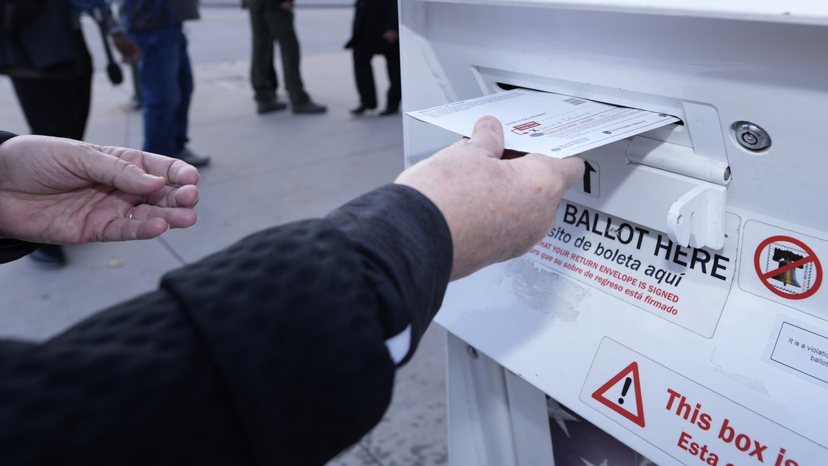 A voter places a ballot in a drop box outside the Denver Elections Division headquarters easrly Tuesday, Nov. 8, 2022, in downtown Denver. (AP Photo/David Zalubowski)