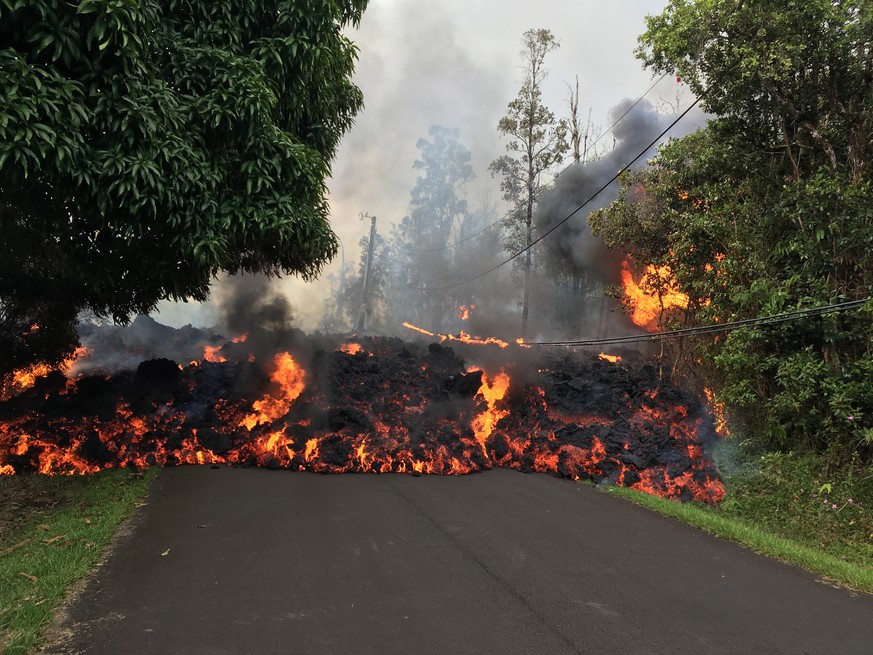 epa06716699 A handout photo made available by the United States Geological Survey (USGS) shows lava flow moving on Makamae Street in Leilani Estates, near Pahoa, Hawaii, USA, 06 May 2018 (issued 07 Ma ...